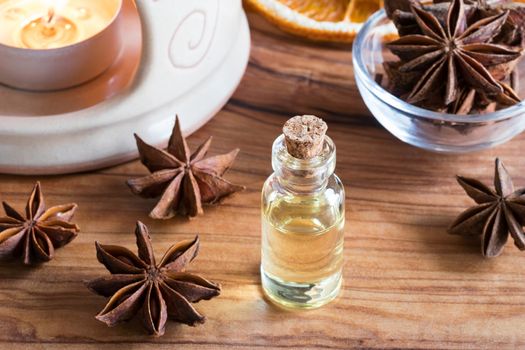 A bottle of star anise essential oil with star anise and an aroma lamp