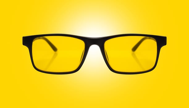 Single sunglasses with black plastic frame and yellow glass on a yelow background