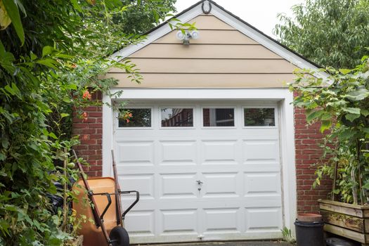 The facade of a brick garage with a white door in the courtyard of the country estate