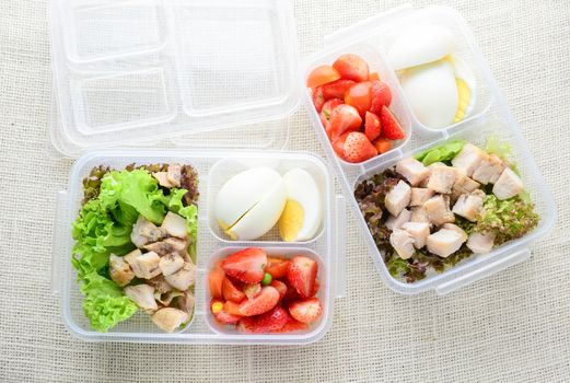 Modern style clean food, boiled egg, grilled chicken and avocado, strawberry, vegetable salad
