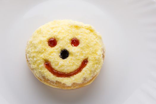 Smiley donut on a white plate, donut with white background  
