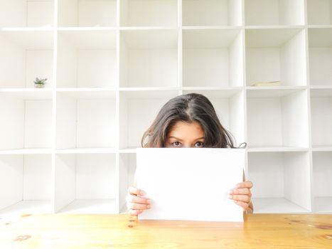 Attractive beautiful woman holding blank white paper.
