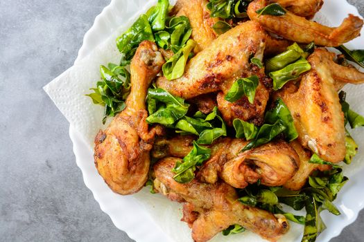 Fried crispy chicken wings, Thigh on white plate with herbs