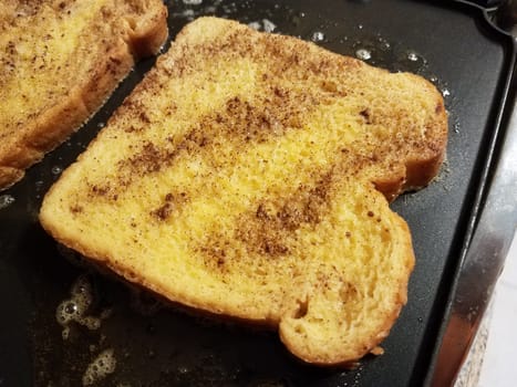 French toast bread with egg and cinnamon cooking on grill or griddle