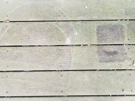 discolored or worn or weathered brown wood deck boards with algae