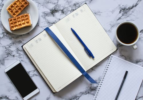 two planners on marble background, coffee, waffles and smartphone - buisness lunch