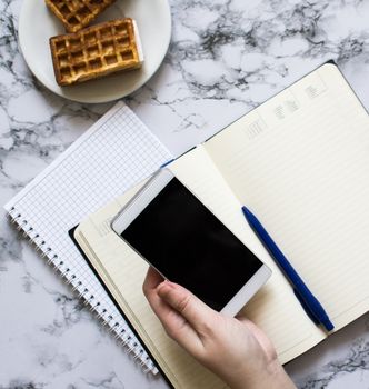 woman hand hold smartphone and planning the day at lunch