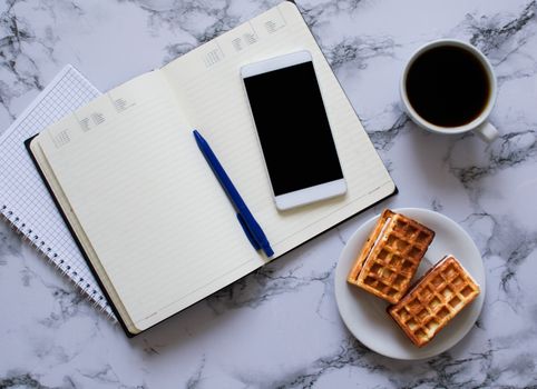 two planners on marble background, coffee, waffles and smartphone - buisness lunch