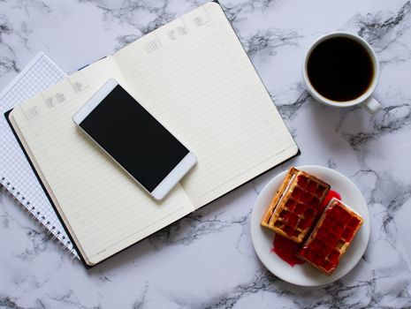 two planners on marble background, coffee, waffles and smartphone - buisness lunch