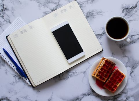 two planners on marble background, coffee, waffles and smartphone - buisness lunch