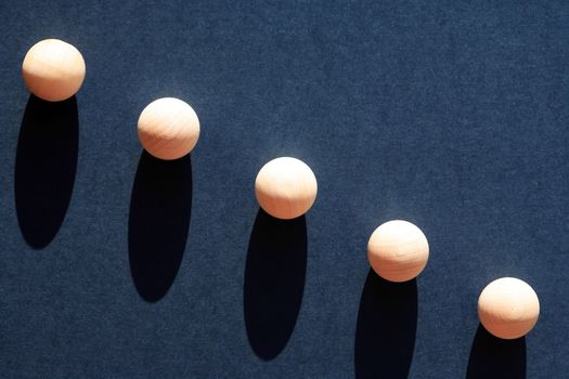 Abstract composition with few small wooden balls on dark blue background