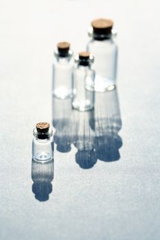 Set of small bottles with long shadow on white background