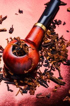 Tobacco pipe with tobacco and scattered virgin tobacco