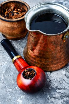 Tobacco pipe with tobacco on slate background