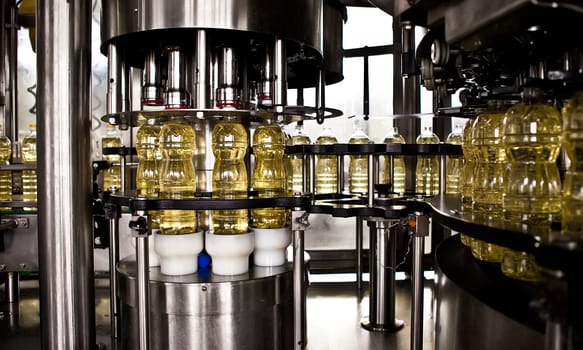 Sunflower oil in the bottle moving on production line. Shallow dof