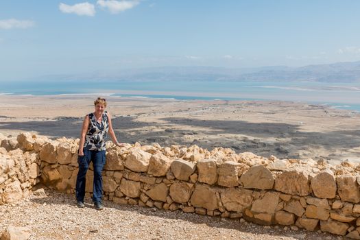 woman resting in masada national park with the dead sea as background