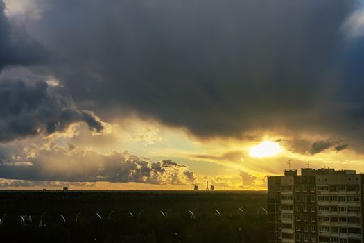 Sun's rays breaking through the thunderclouds on the outskirts of the city.