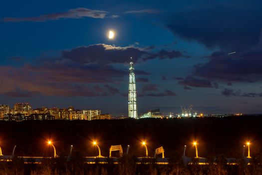 night cityscape. View of the Lakhta Center tower in St. Petersburg in the sunset with clouds and moon.