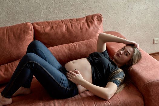 Young pregnant woman. Pregnant beautiful woman posing at home. Happy pregnancy. Woman expecting baby. Maternity. Healthy pregnancy concept, parenthood.