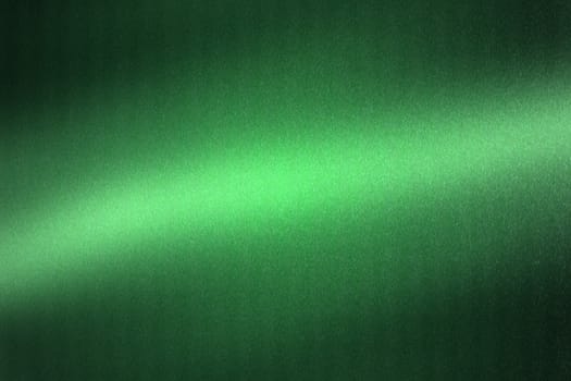 Light shining on green metallic plate in dark room, abstract texture background