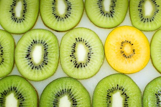 A Yellow Slice of Kiwi Among Green Slices