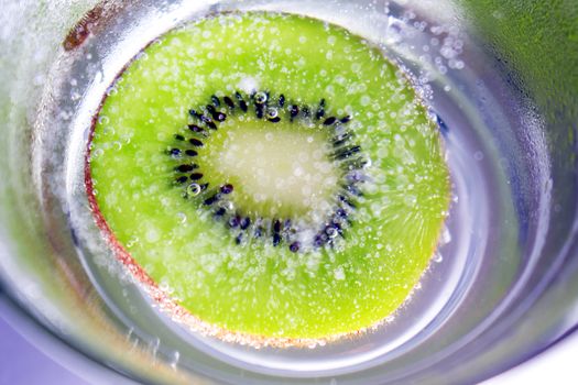 Sliced Kiwi Dropped in a Glass of Fizzy Water