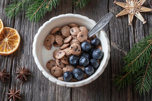 Breakfast cereals with yogurt and blueberries, with spruce branches and Christmas decoration