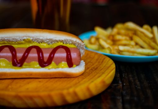 Hot dog and chips on wooden background