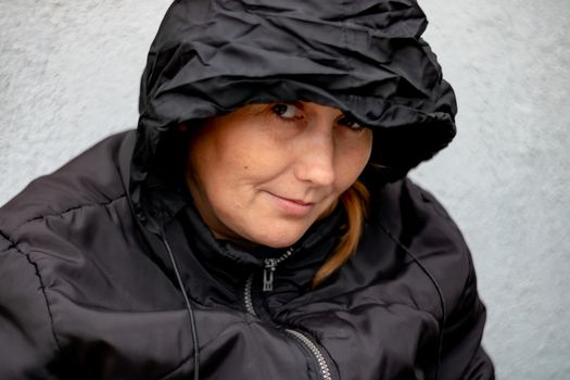 Woman with black hood in a yard