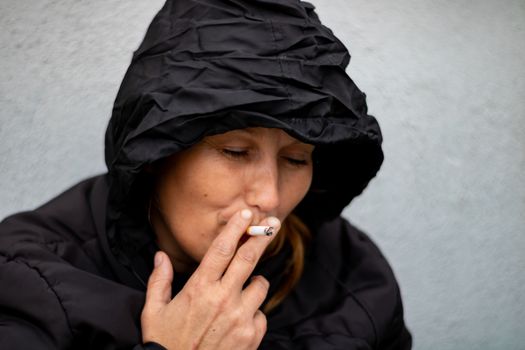 Woman with black hood in a yard