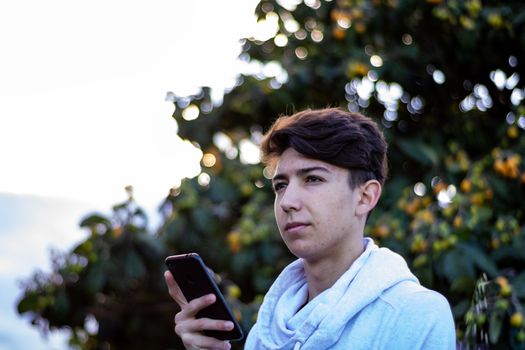 Young boy posing with a tree in the background