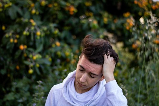 Young boy posing with a tree in the background