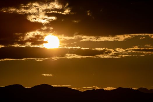 Sunset over mountains with storms clouds