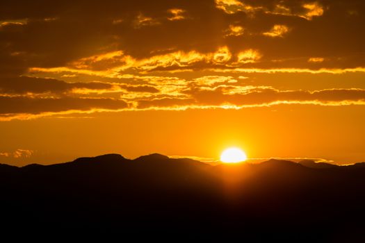 Sunset over mountains with storms clouds