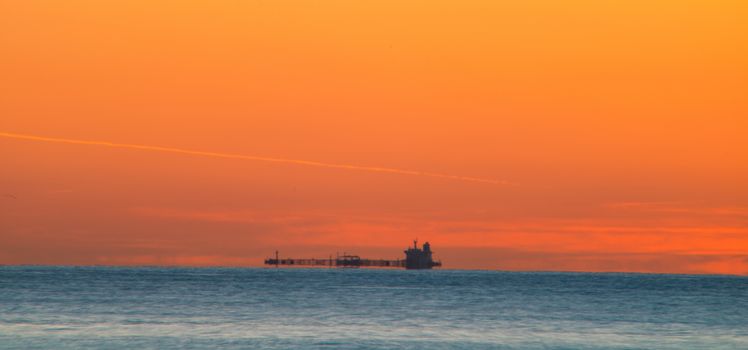 Freighter sailing at sunrise in the Mediterranean Sea