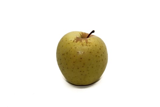 Yellow apple with brown spots on white background