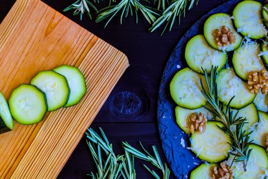 Carpaccio of zucchini with nuts and cheese on dark wooden background