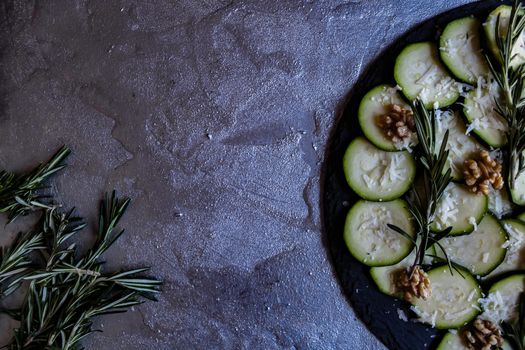 Carpaccio of zucchini with nuts and cheese on gray background