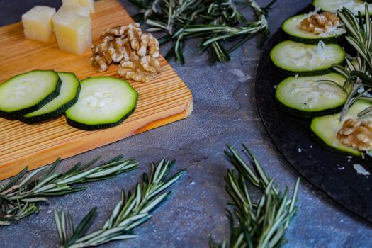 Carpaccio of zucchini with nuts and cheese on gray background