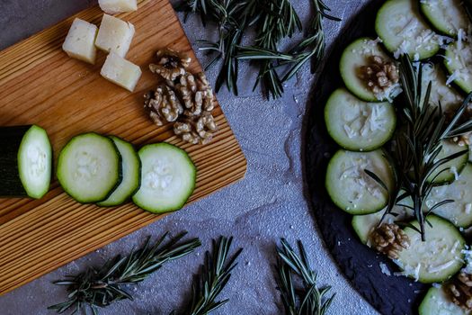 Carpaccio of zucchini with nuts and cheese on gray background