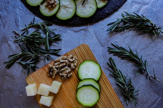 Carpaccio of zucchini with nuts and cheese on gray background