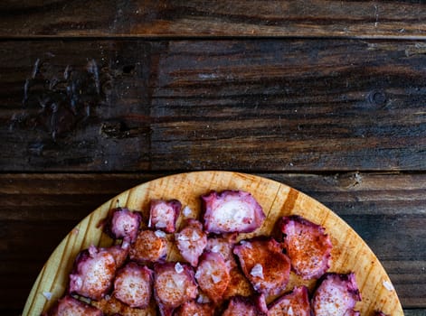 View of Galician octopus dish on old wooden background