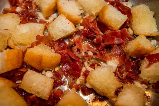 Stir fried garlic, ham and bread in olive oil
