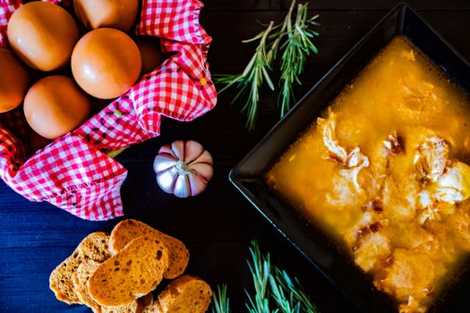 Typical Spanish garlic soups in composition on dark wood background
