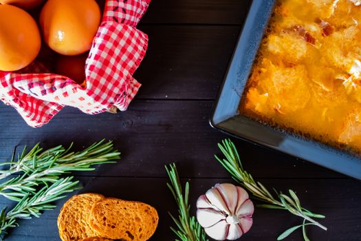 Typical Spanish garlic soups in composition on dark wood background