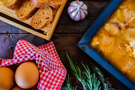 Typical Spanish garlic soups in composition on wood background