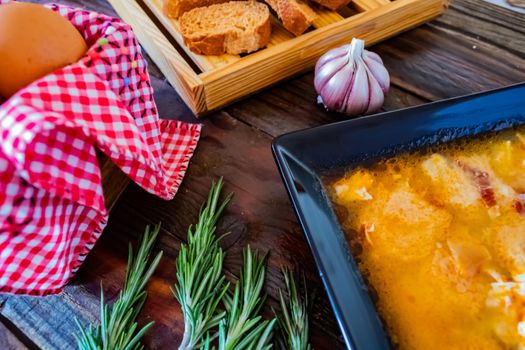 Typical Spanish garlic soups in composition on wood background