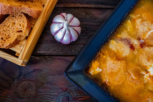 Typical Spanish garlic soups in composition on wood background