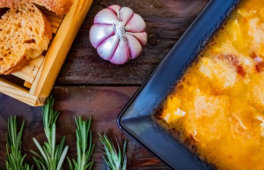 Typical Spanish garlic soups in composition on wood background