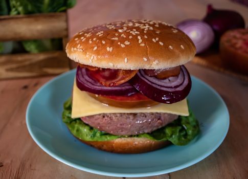 Hamburger and ingredients in composition on wooden background